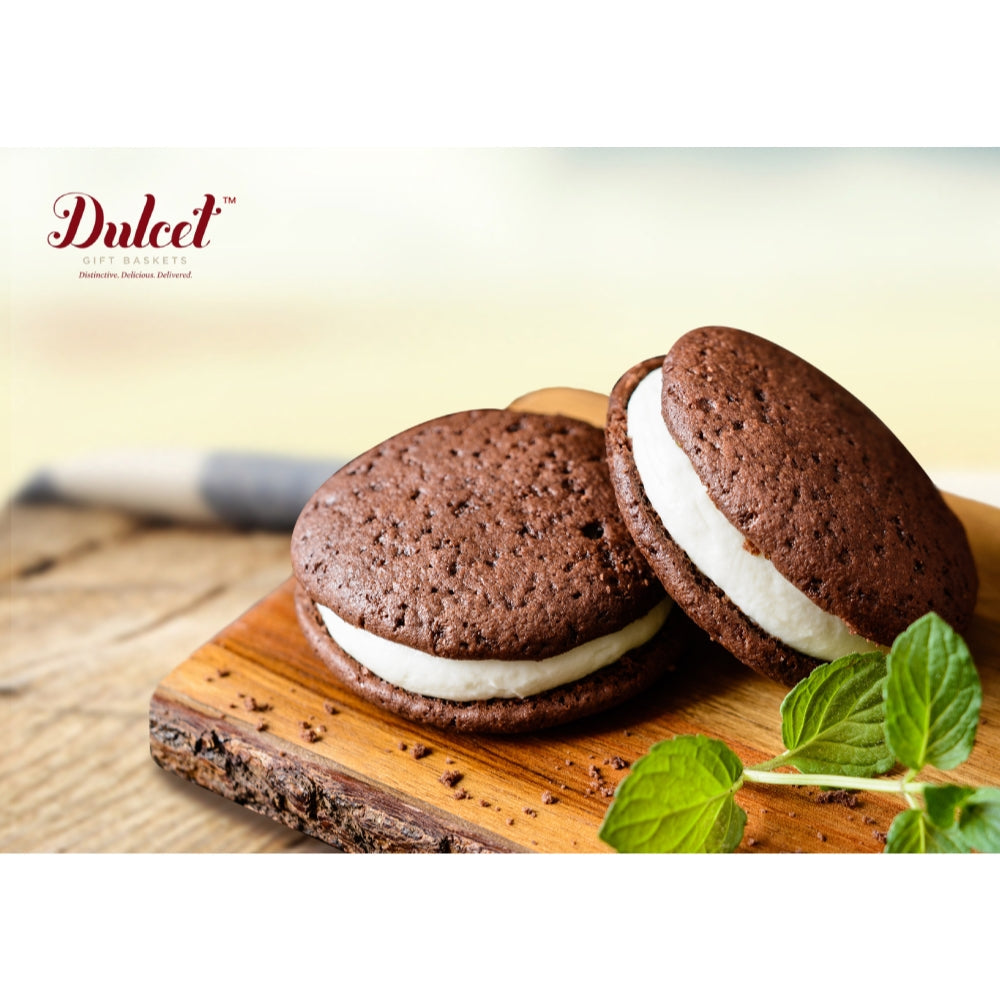 Chocolate sandwich cookies with white filling on a wooden board, featuring the Dulced brand.
