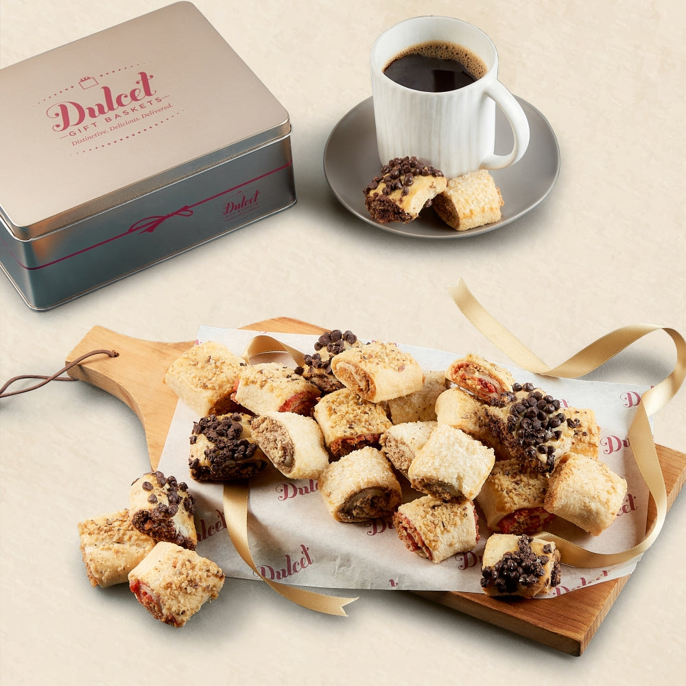 Assorted Rugelach on a wooden board with a cup of coffee and Dulced tin box.